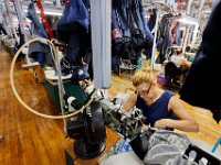 Stitchers are seen making suit jackets under a conveyor belt system that eases the transportation between stations, at the Joseph Abboud manufacturing plant in New Bedford, MA.   [ PETER PEREIRA/THE STANDARD-TIMES/SCMG ]